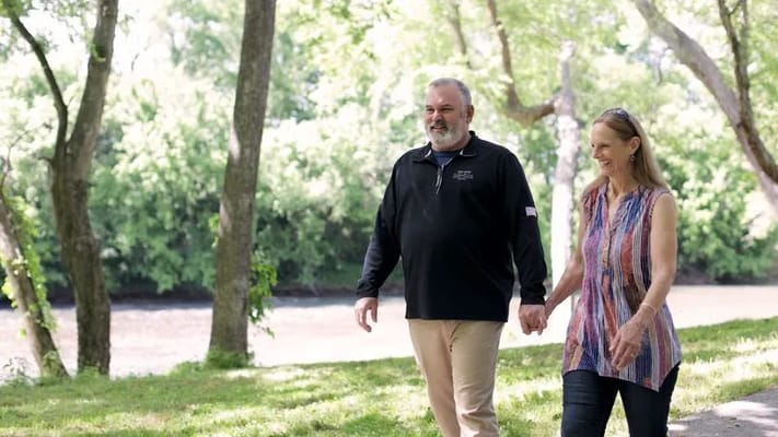 Couple walking hand in hand along a riverbank