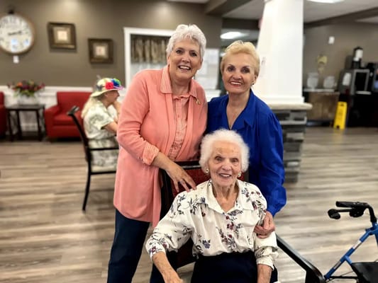 Residents and staff members smiling together in a common area