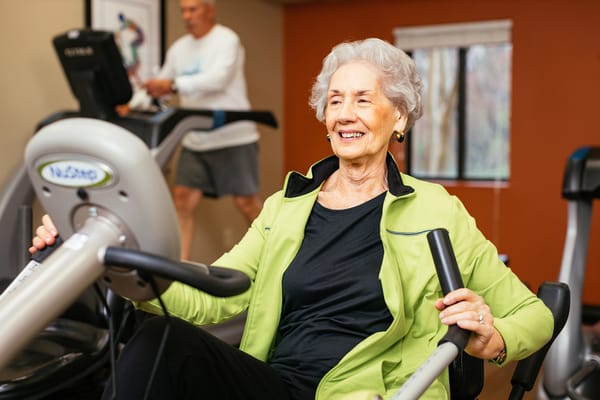 Senior resident exercising on fitness equipment.