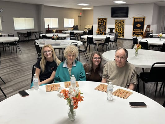 Residents and staff sitting at tables in a common area