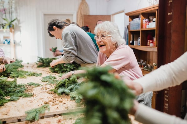 Residents engaging in a crafting activity with greenery