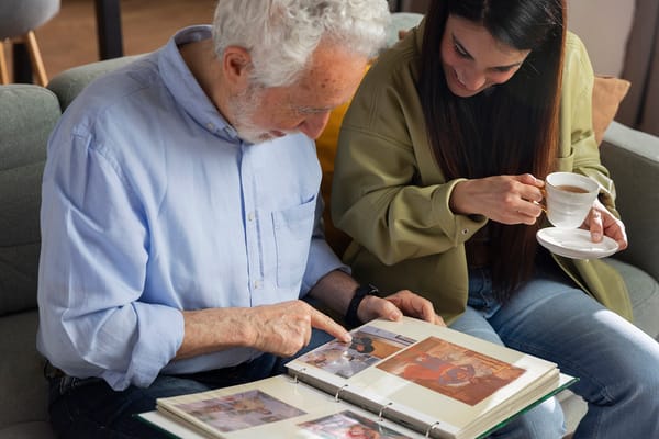 An elderly man and a woman looking through a photo album