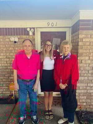 A staff member with two residents at the entrance