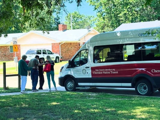 Residents interacting near a facility shuttle van