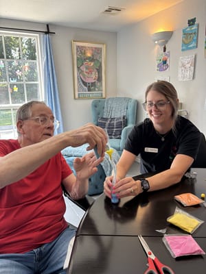 A resident and staff member engaged in a creative activity