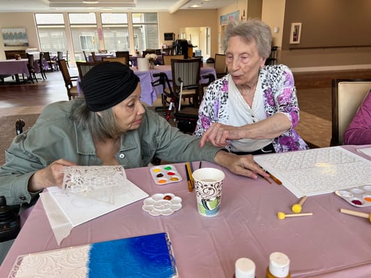 Residents engaging in an art activity at a table