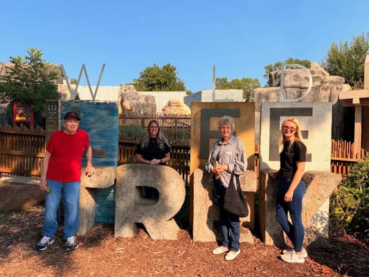 Residents posing with letters in an outdoor space