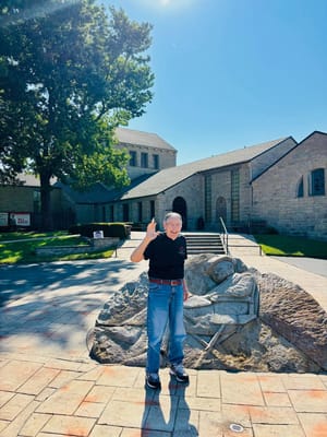 Resident waving at the facility entrance with sculpture