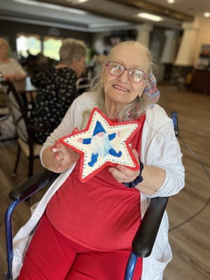 Resident proudly displaying a craft in a communal area