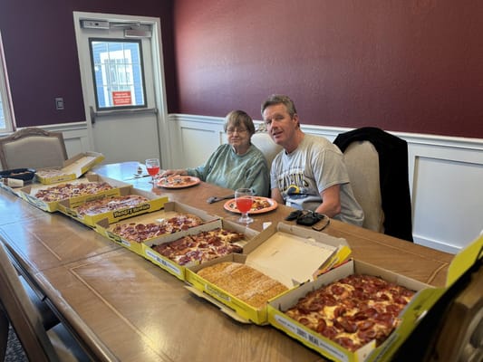 Residents enjoying pizza together in a dining area