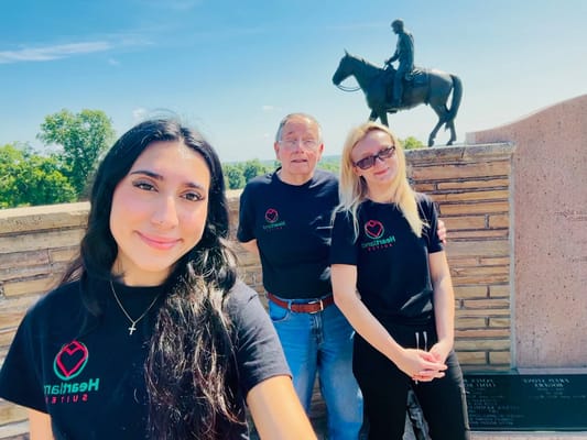 Group photo of staff and resident outdoors