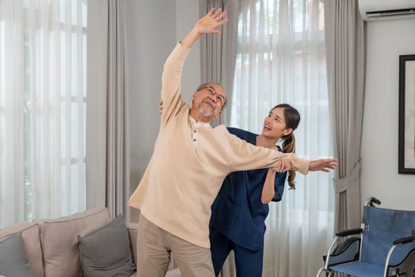 A caregiver assisting a senior resident in stretching exercises
