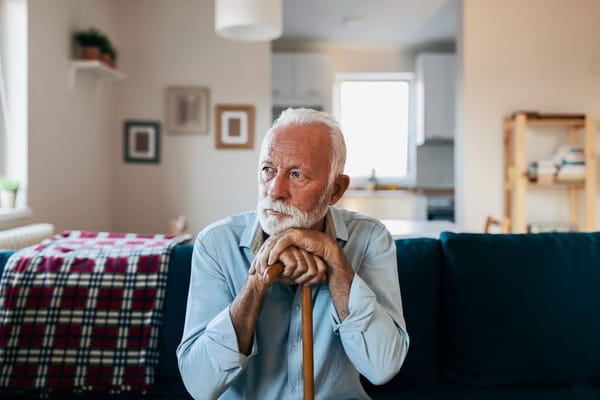 Senior man sitting thoughtfully in a cozy living space