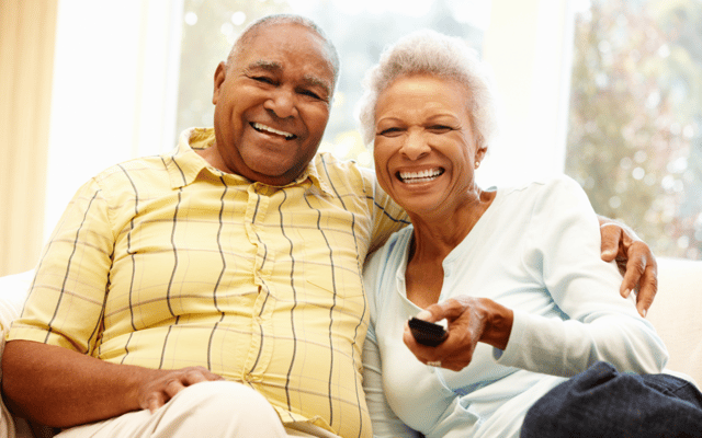 Two smiling residents sitting together on a couch