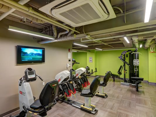 Well-equipped fitness center with exercise machines and a TV