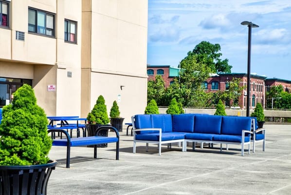 Outdoor seating area with blue furniture and greenery