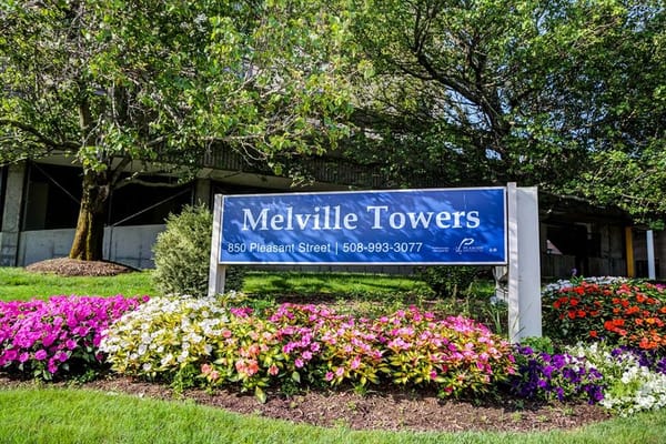 Signage for Melville Towers with flowers in foreground