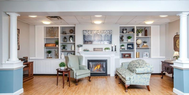 Lounge area with seating and fireplace at River Falls Senior Living