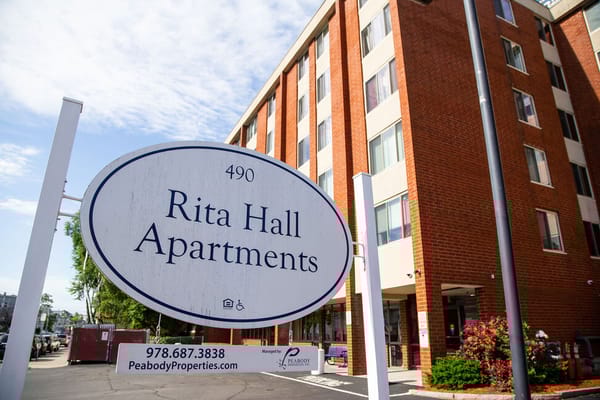Exterior view of Rita Hall Apartments with signage