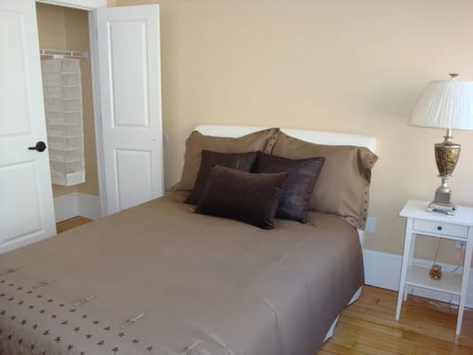 Bedroom with a bed, decorative pillows, and lamp