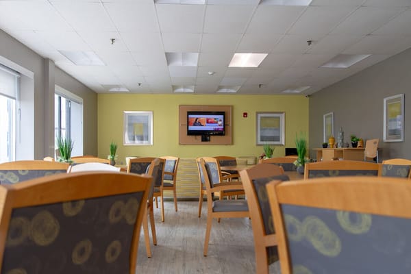 Bright common area with tables and a TV.