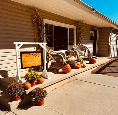 Front entrance with decorative pumpkins and flowers at Silver Linings Senior Living