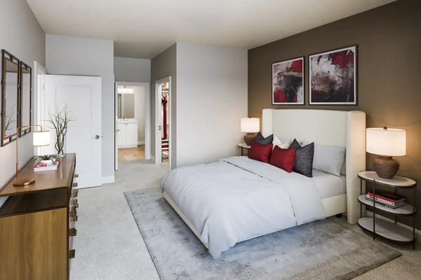 A well-decorated bedroom with a queen bed and stylish furnishings.