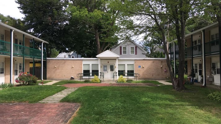 Front entrance of the Orange Street senior living facility surrounded by greenery.