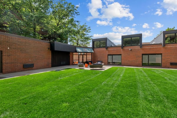 A cozy outdoor lounge with seating on a well-maintained lawn.