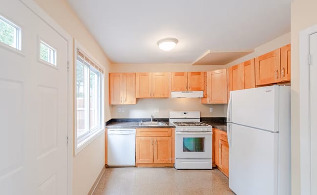Bright kitchen with modern appliances and light wood cabinets