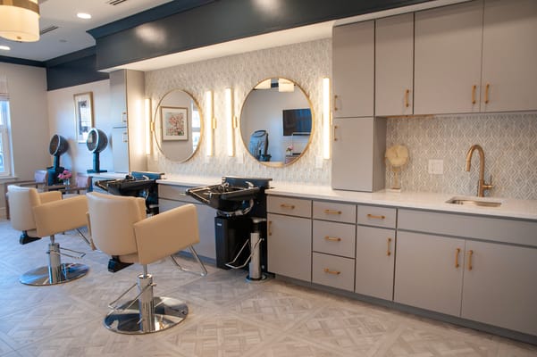 Bright salon area with styling stations and mirrors