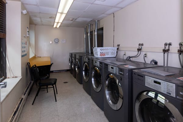 Laundry room with washing machines and a chair