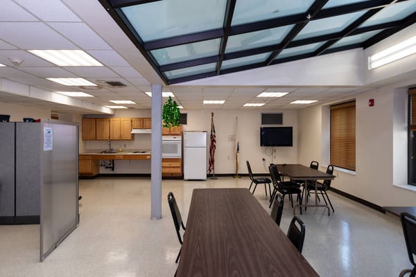 Bright common area with tables and kitchenette