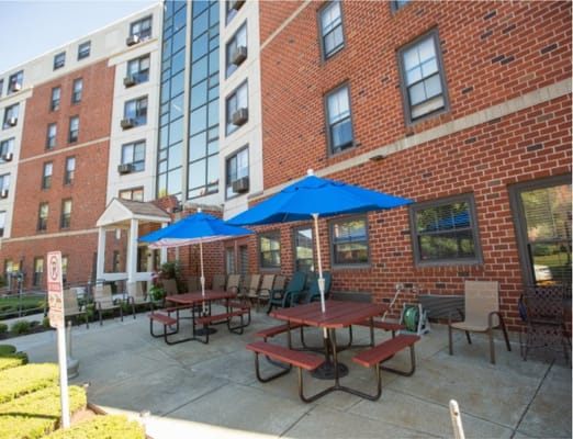 Seating area with blue umbrellas and tables in front of a building