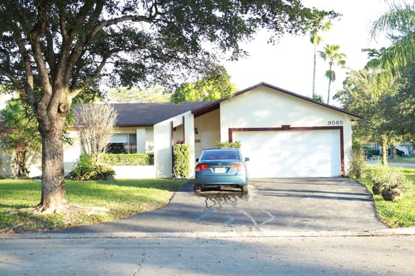 Exterior view of a residential care facility with a parked car
