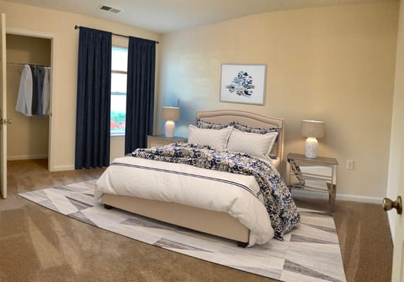 A well-decorated bedroom featuring a bed, nightstand, and window with dark curtains.