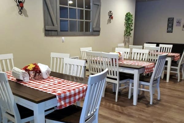 Bright dining area with white tables and red checkered tablecloths
