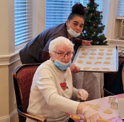 Residents and staff making cookies in the activity room
