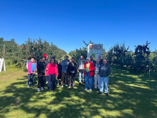 Residents enjoying an outdoor outing at an apple orchard