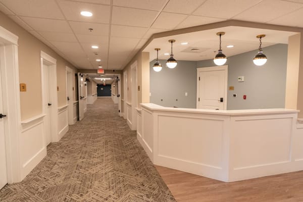 Interior hallway with overhead lighting and carpet