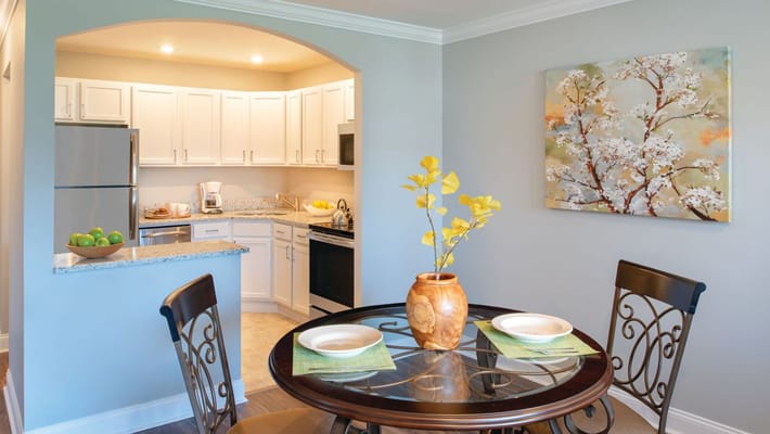 Bright interior of a dining area with a table and kitchen view
