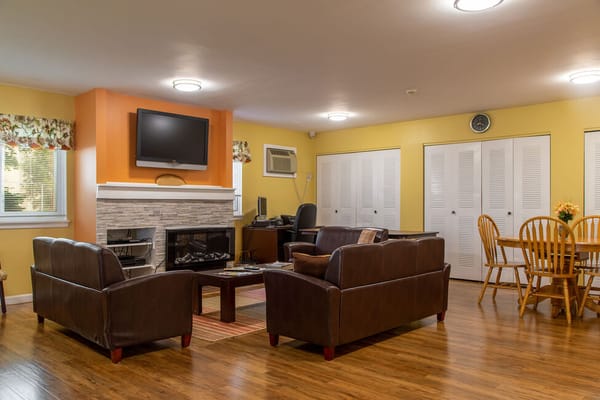 Lounge area with leather sofas, a fireplace, and a dining table