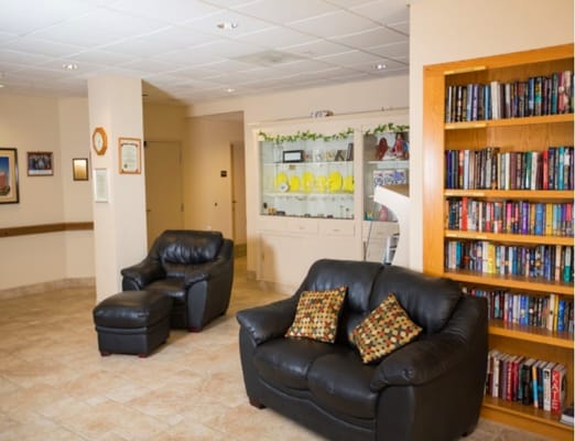 Cozy lobby area with leather chairs and a bookshelf