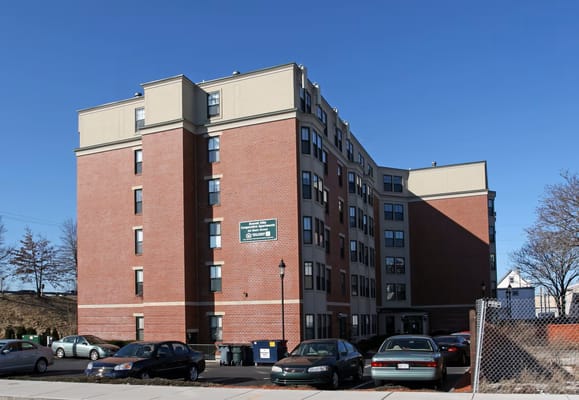 Brick building of Everett Villa Co-op with parked cars in front.
