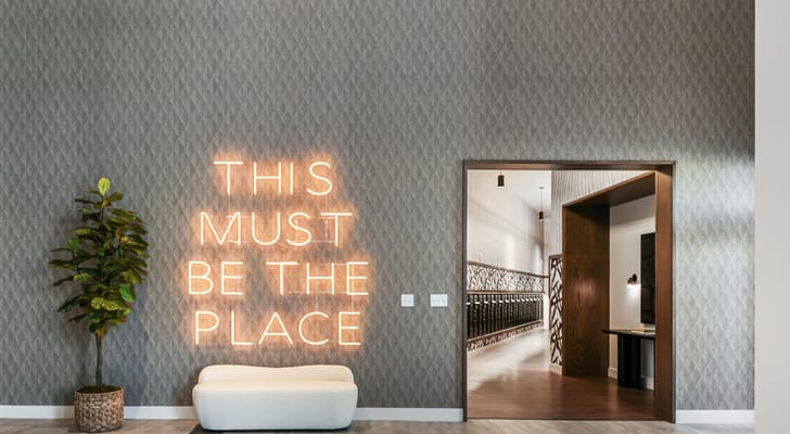 Illuminated sign reading 'THIS MUST BE THE PLACE' in the lobby.
