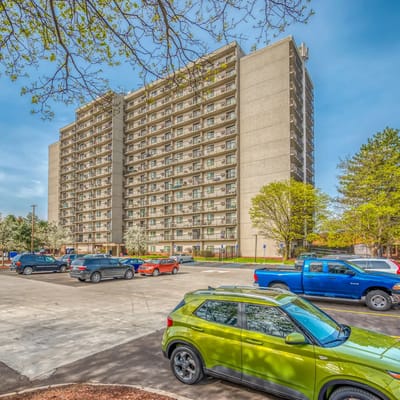 Exterior view of Cambridge Towers with parked vehicles