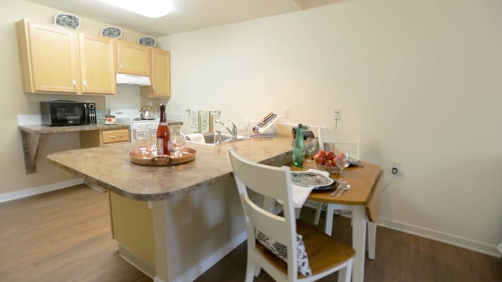 Cozy dining area with kitchen and apples on the table
