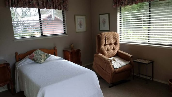 Cozy resident room with bed and recliner chair