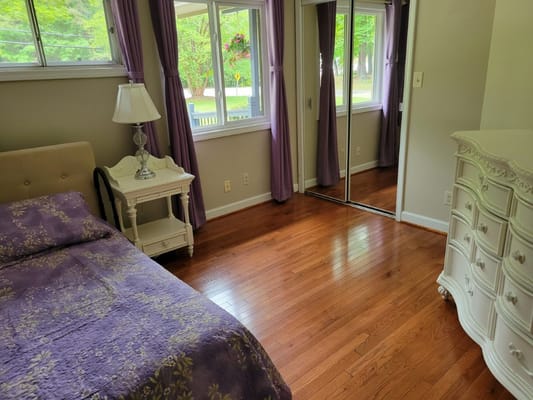Inside view of a cozy bedroom with a bed and dresser.