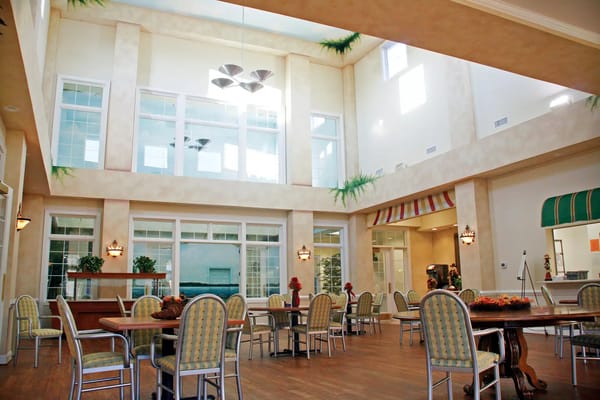 Interior view of a bright common area with dining tables and chairs